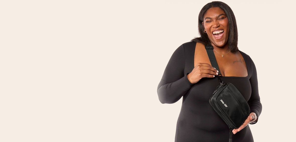 Laughing woman wearing the black Hello Clio Original crossbody belt bag